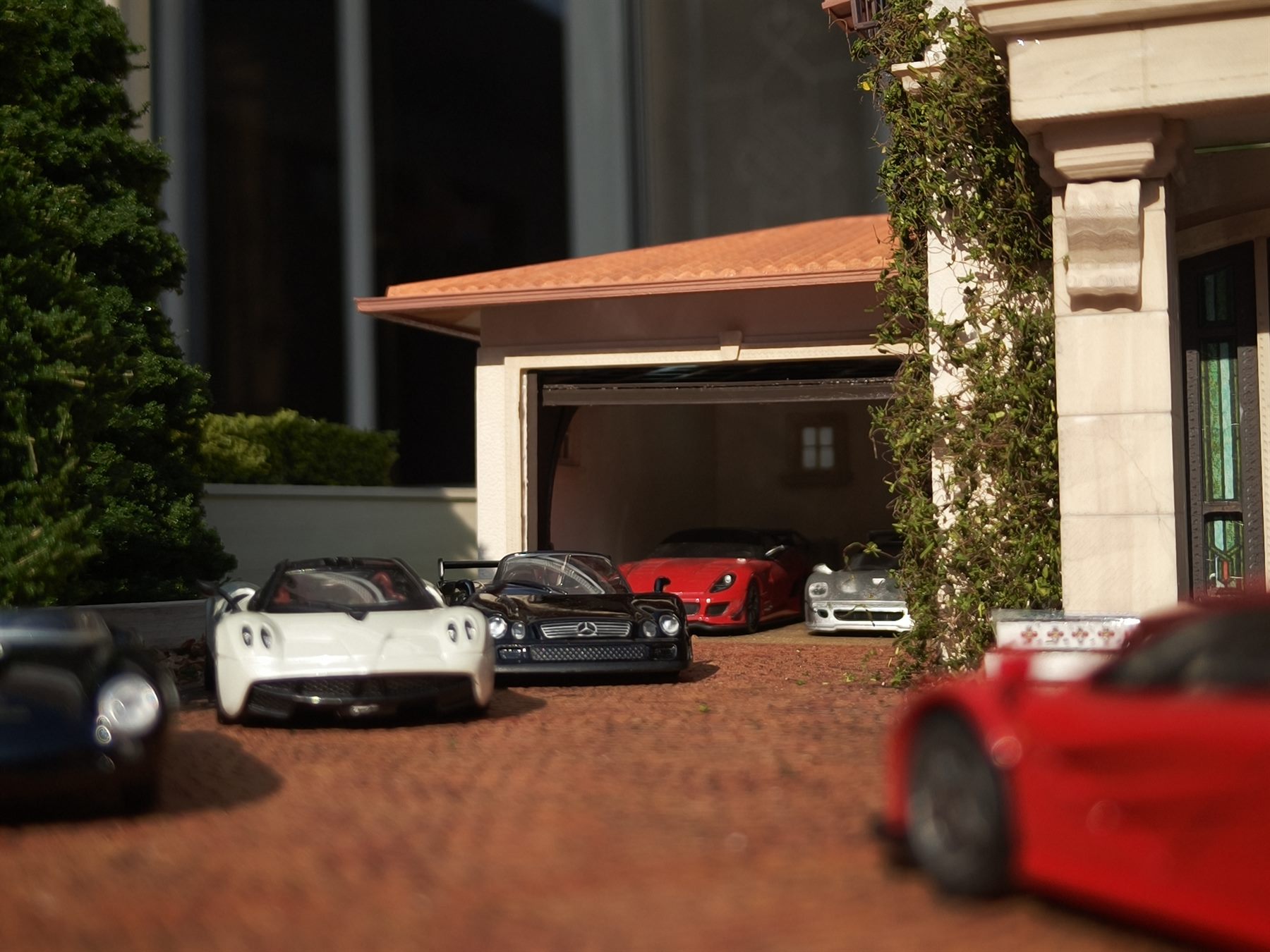 Multiple 1:64 cars displayed on the driveway